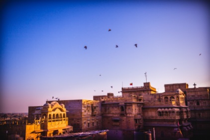 Where am I? Dance the pigeons around my head like on any public place in Paris. The sun rising over the desert is starting to reveal the golden buildings arising from the sand. Is this sun the same as before? Is there only one sun lighting all the places in the world? Certainly not. Jaisalmer, India, 2014